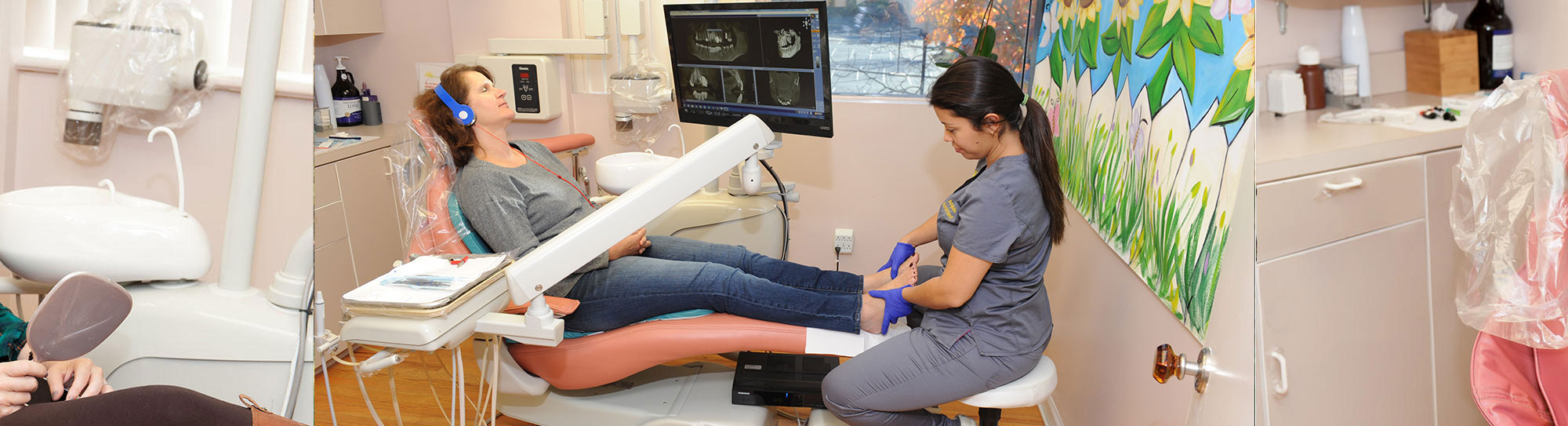 patient sitting in dentist chair getting pampered, with eyes closed, wearing headphones and a member of the staff is rubbing her feet